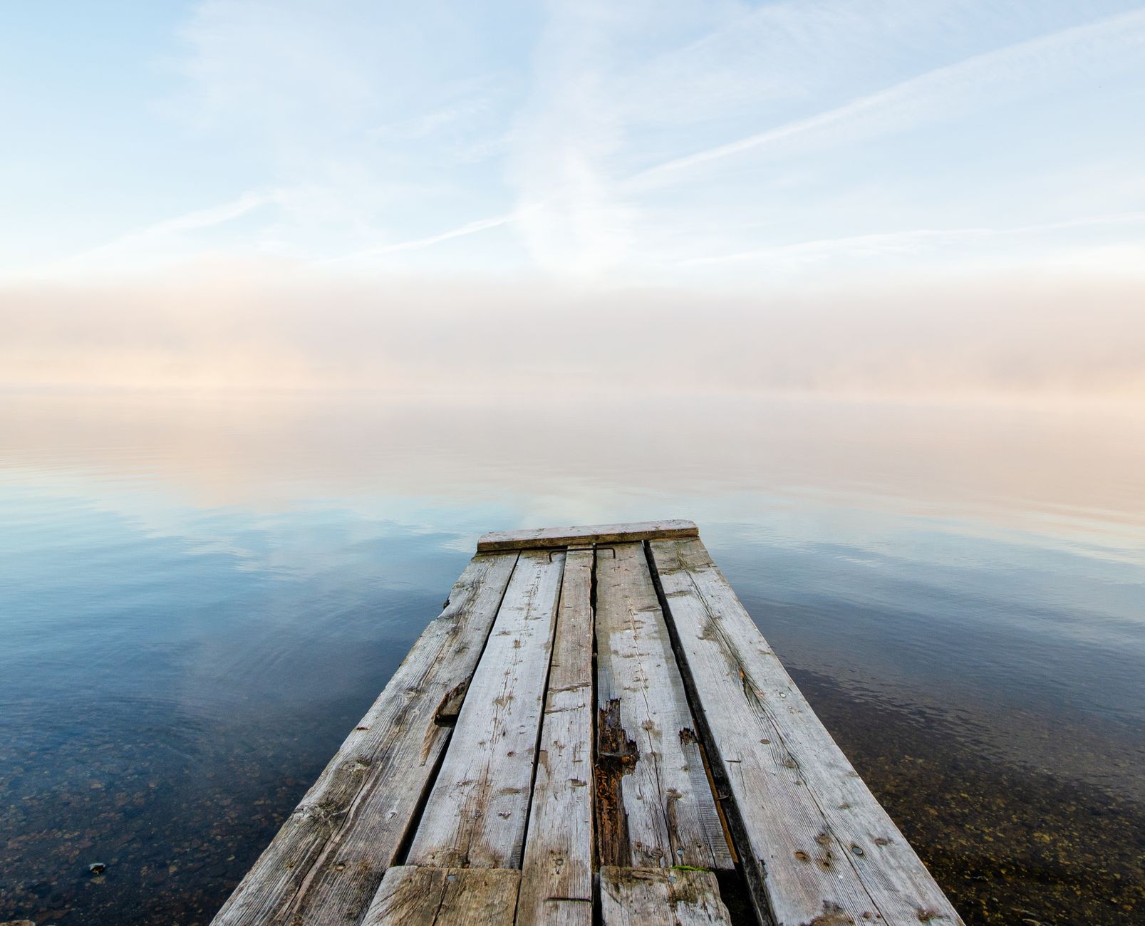 Misty lake at dawn, calm and still